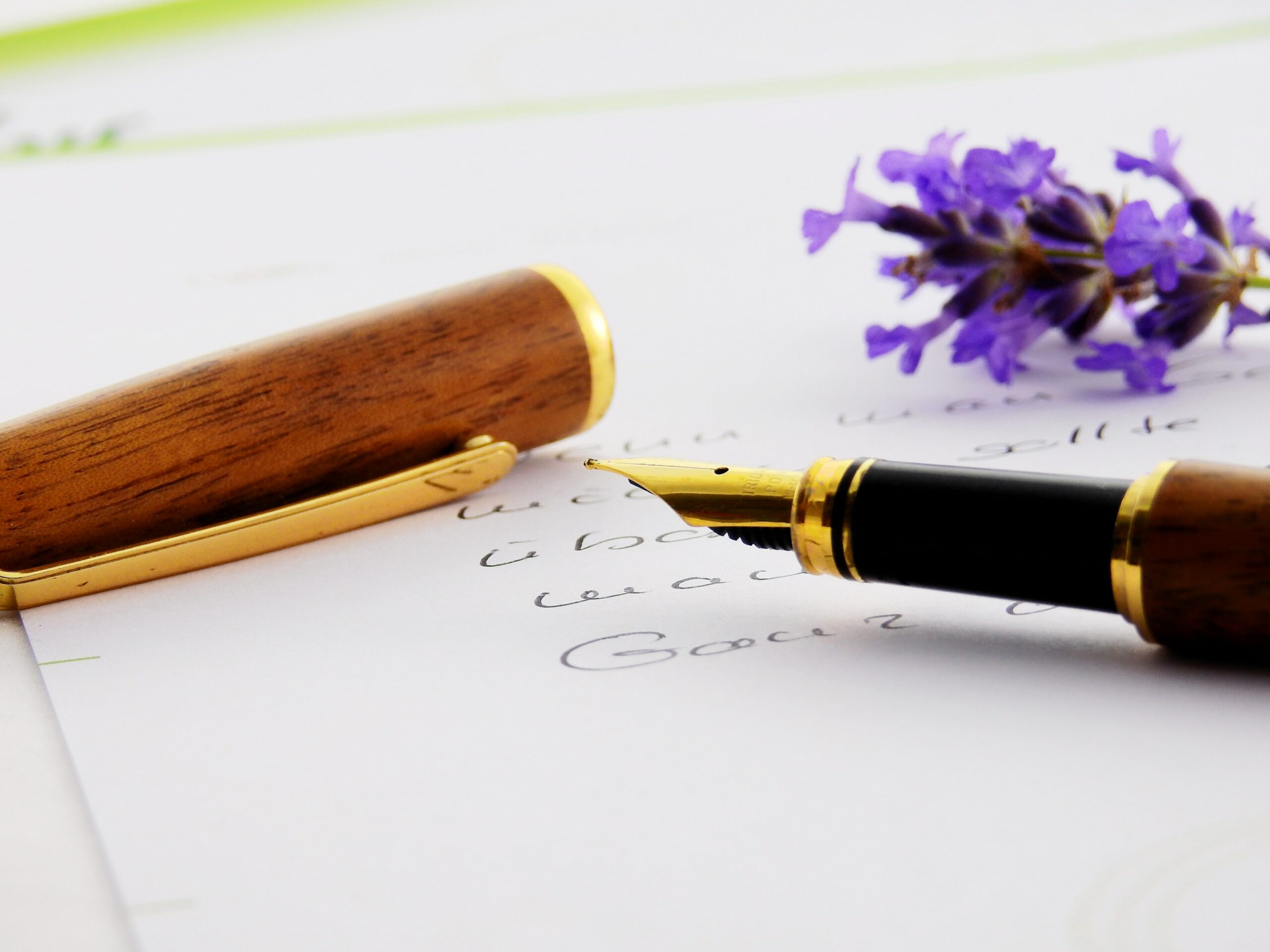 un stylo plume sur un papier avec une fleur violette